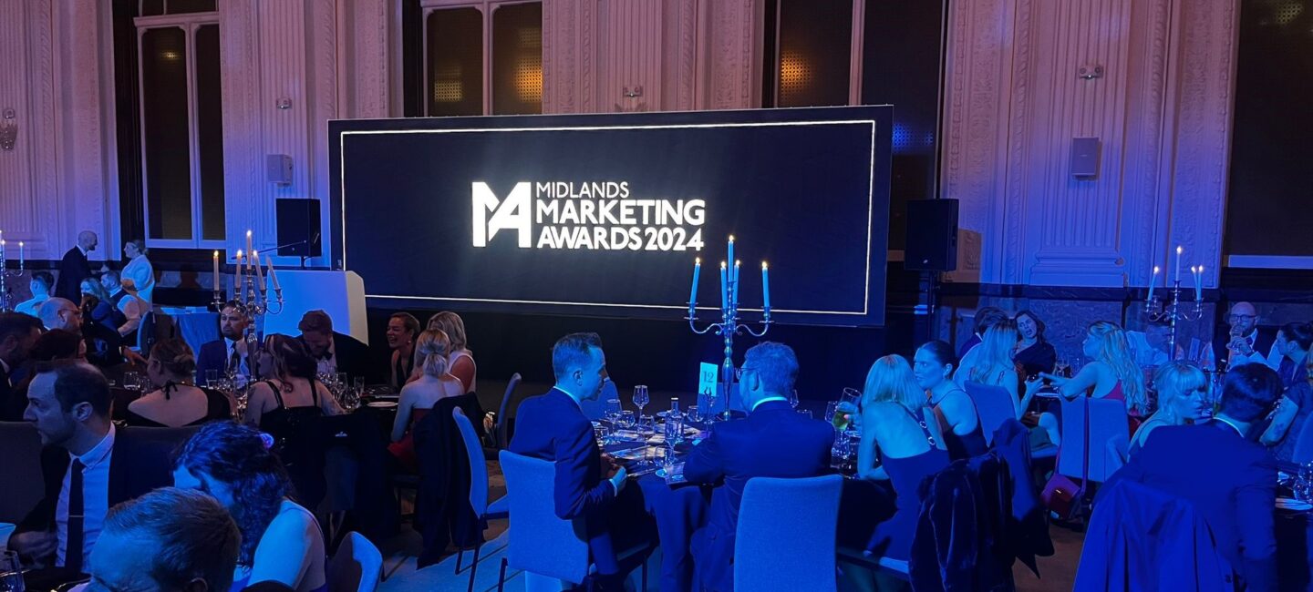 The midlands marketing awards ceremony, with people sitting at round tables and a stage.