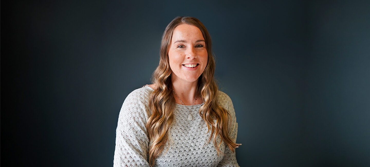 Shannon Peerless sitting at a desk smiling